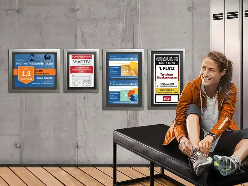 Eine Frau bindet sich ihren Sportschuh zu. Sie sitzt in der Umkleide und hinter ihr an der Wand hängen die Auszeichnungen der VIACTIV Krankenkasse. | VIACTIV Krankenkasse