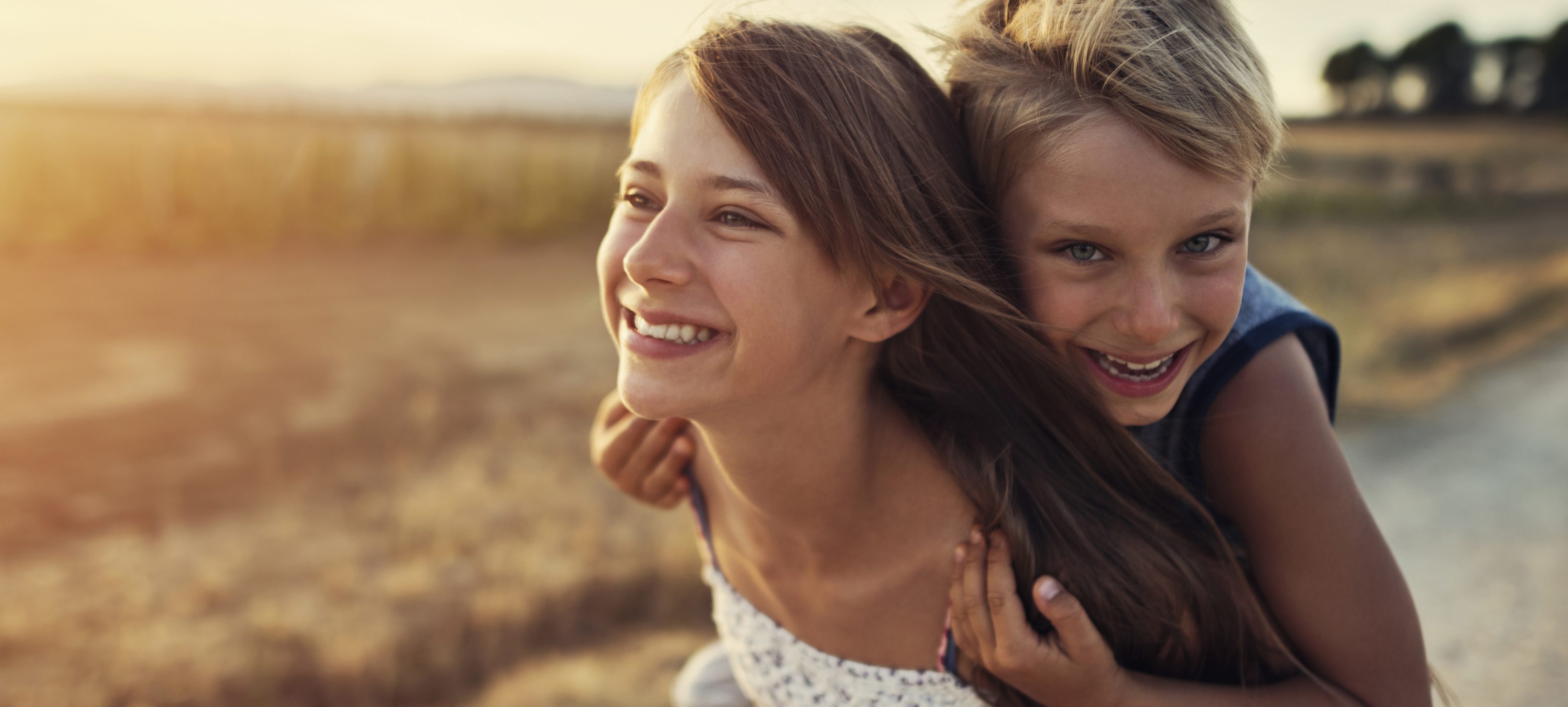Little girl giving her brother a piggyback ride | VIACTIV Krankenkasse