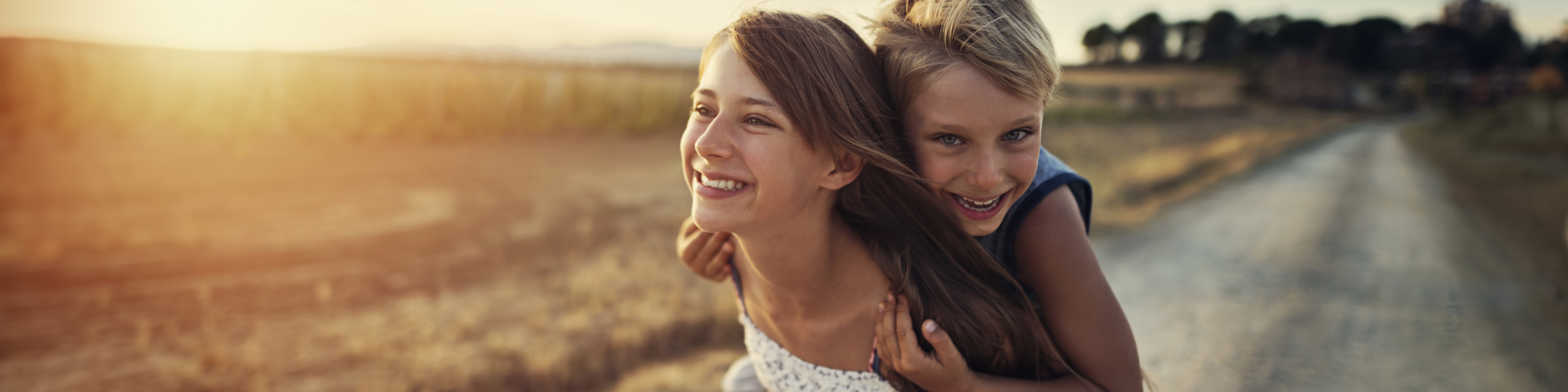 Little girl giving her brother a piggyback ride | VIACTIV Krankenkasse