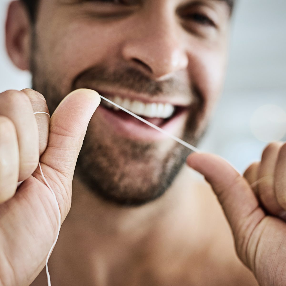 Ein Mann lächelt in die Kamera. Dank professioneller Zahnreinigung (PZR) hat er gesunde Zähne. | VIACTIV Krankenkasse