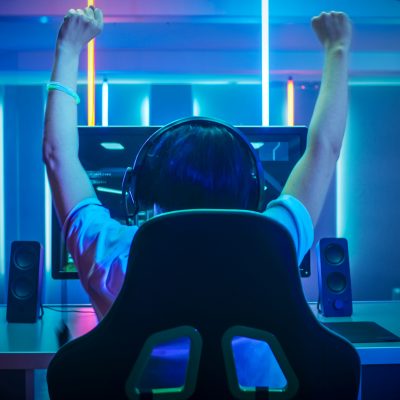 Professional Gamer Playing and Winning in First-Person Shooter Online Video Game on His Personal Computer. Footage Fade out into Bokeh. Room Lit by Neon Lights in Retro Arcade Style. Cyber Sport Championship. | VIACTIV Krankenkasse