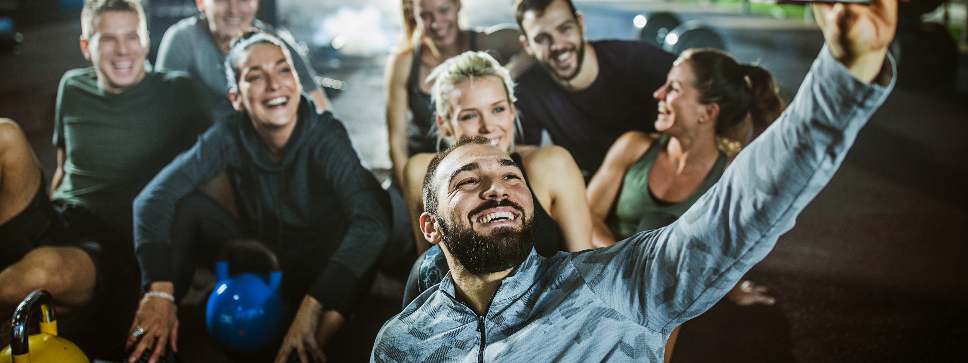 Large group of happy athletic friends taking a selfie on a break in a gym. | VIACTIV Krankenkasse