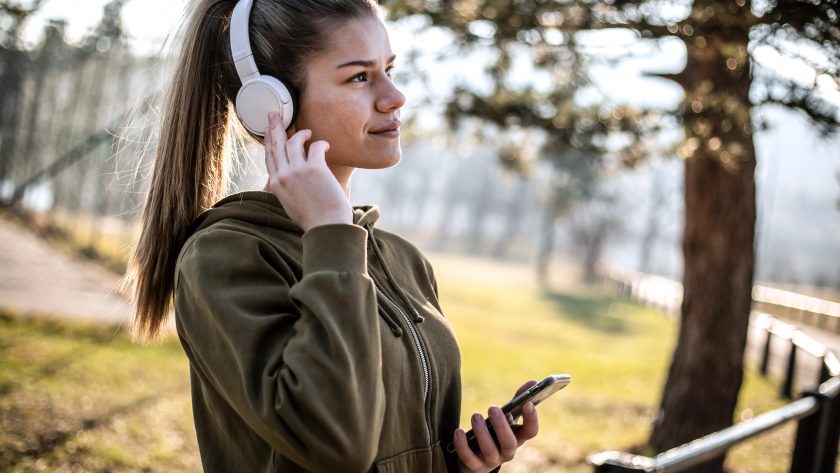 Fit young woman listening to music on headphones after training outdoors - | VIACTIV Krankenkasse