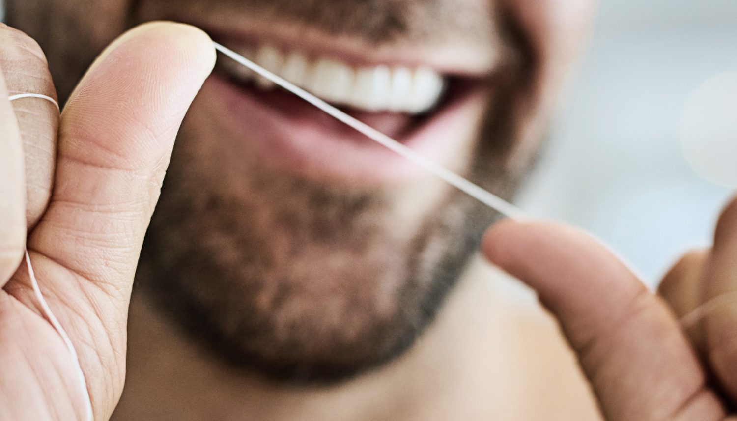 Ein Mann lächelt in die Kamera. Dank professioneller Zahnreinigung (PZR) hat er gesunde Zähne. | VIACTIV Krankenkasse