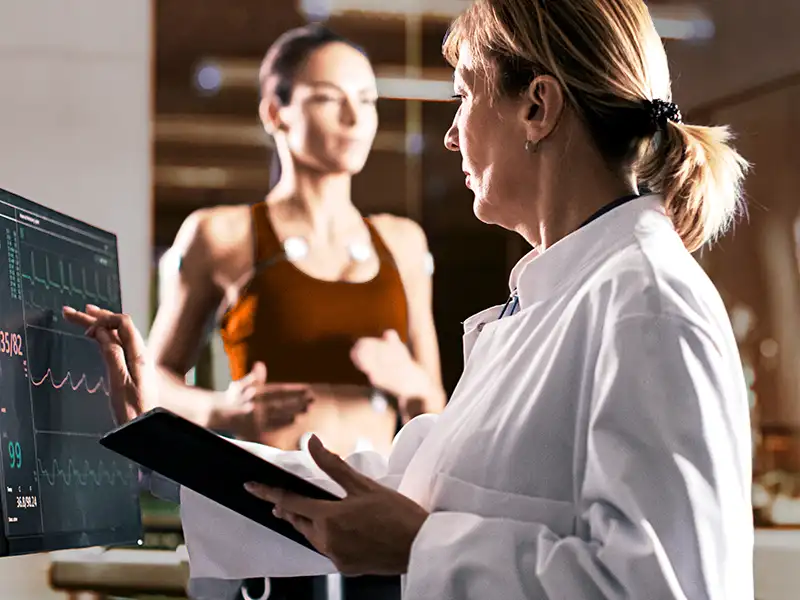 Eine Ärztin führt ein Belastungs-EGK bei einer Patientin im Rahmen des Sportchecks durch. | VIACTIV Krankenkasse