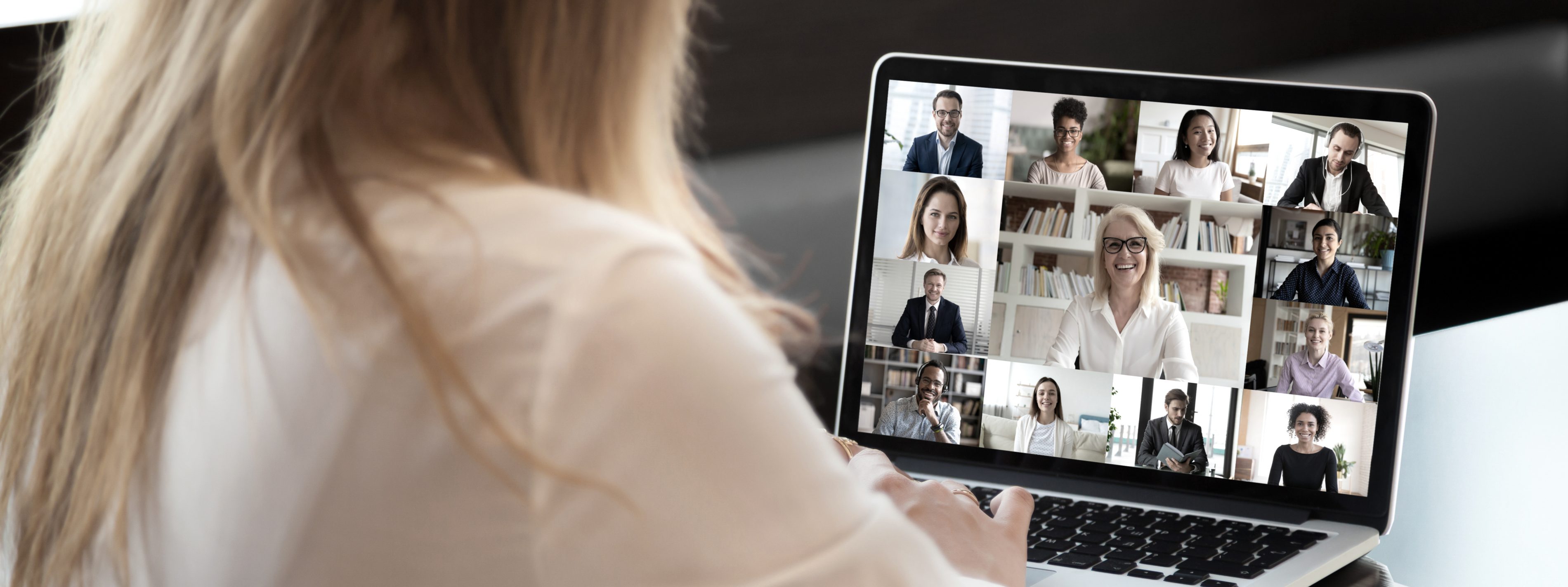Businesspeople communicating using application webcam laptop view over businesswoman shoulder | VIACTIV Krankenkasse