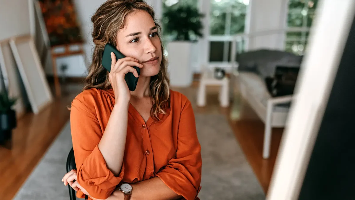Eine Frau, die ein Smartphone am Ohr hält und offensichtlich telefoniert. | VIACTIV Krankenkasse