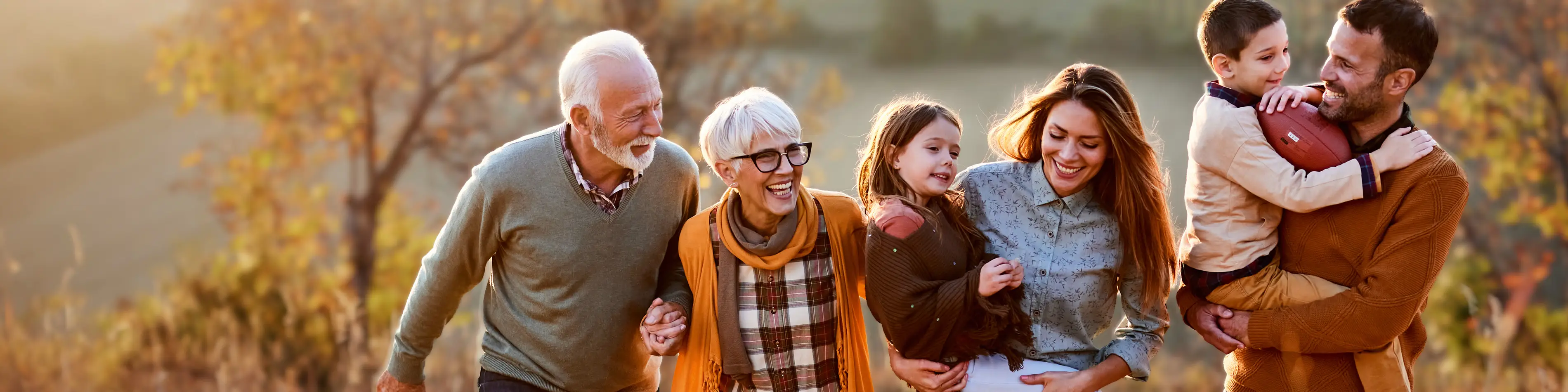 Eine sechsköpfige Familie geht gemeinsam durch die Natur. Es herbstlich aus. | VIACTIV Krankenkasse