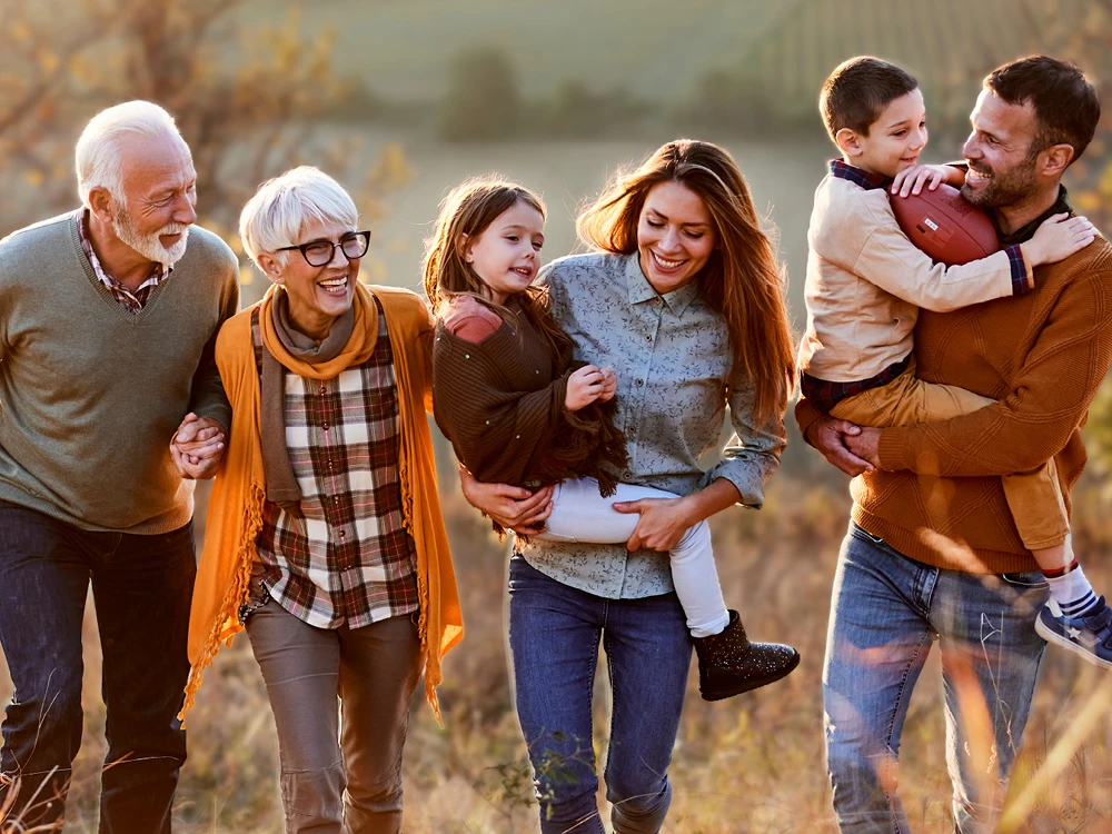 Eine sechsköpfige Familie geht gemeinsam durch die Natur. Es herbstlich aus. | VIACTIV Krankenkasse