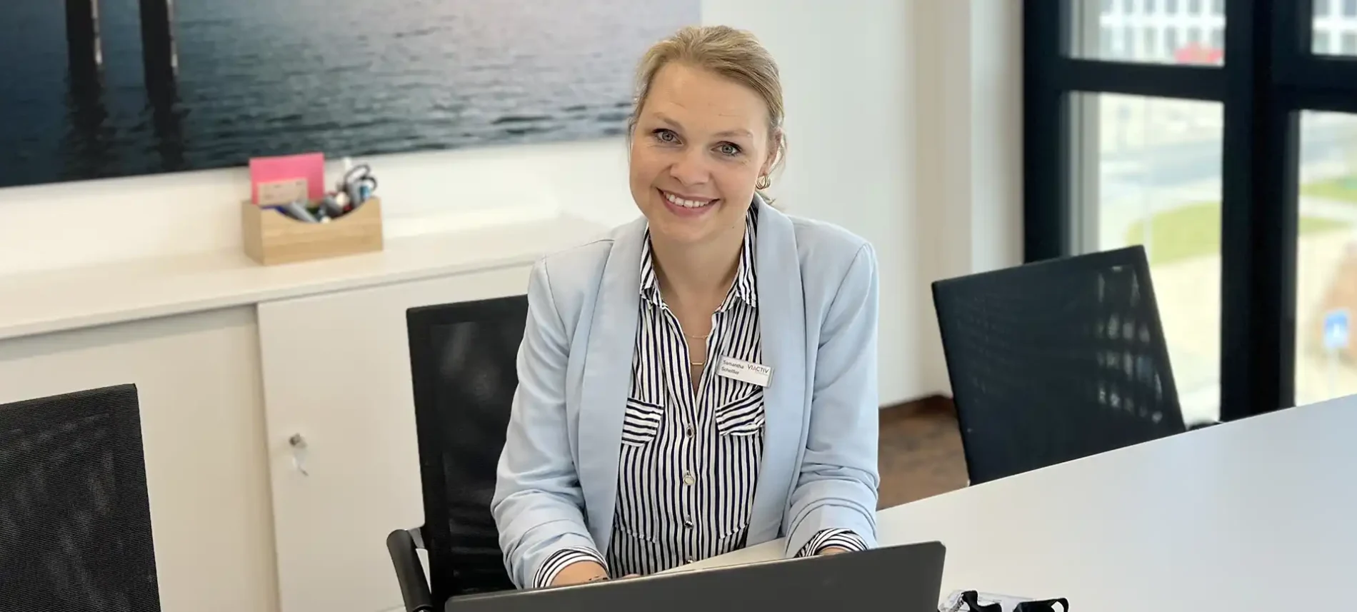 Auf dem Bild ist eine Mitarbeiterin der VIACTIV Krankenkasse zu sehen. Sie sitzt am Schreibtisch. Ein Laptop steht vor ihr. | VIACTIV Krankenkasse