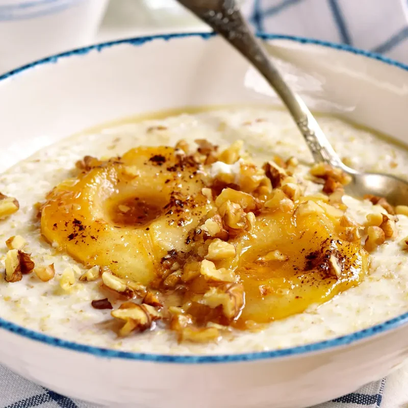 Apfel-Birnen-Porridge mit Zimt und einer Nussgarnitur in einer Schale. | VIACTIV Krankenkasse