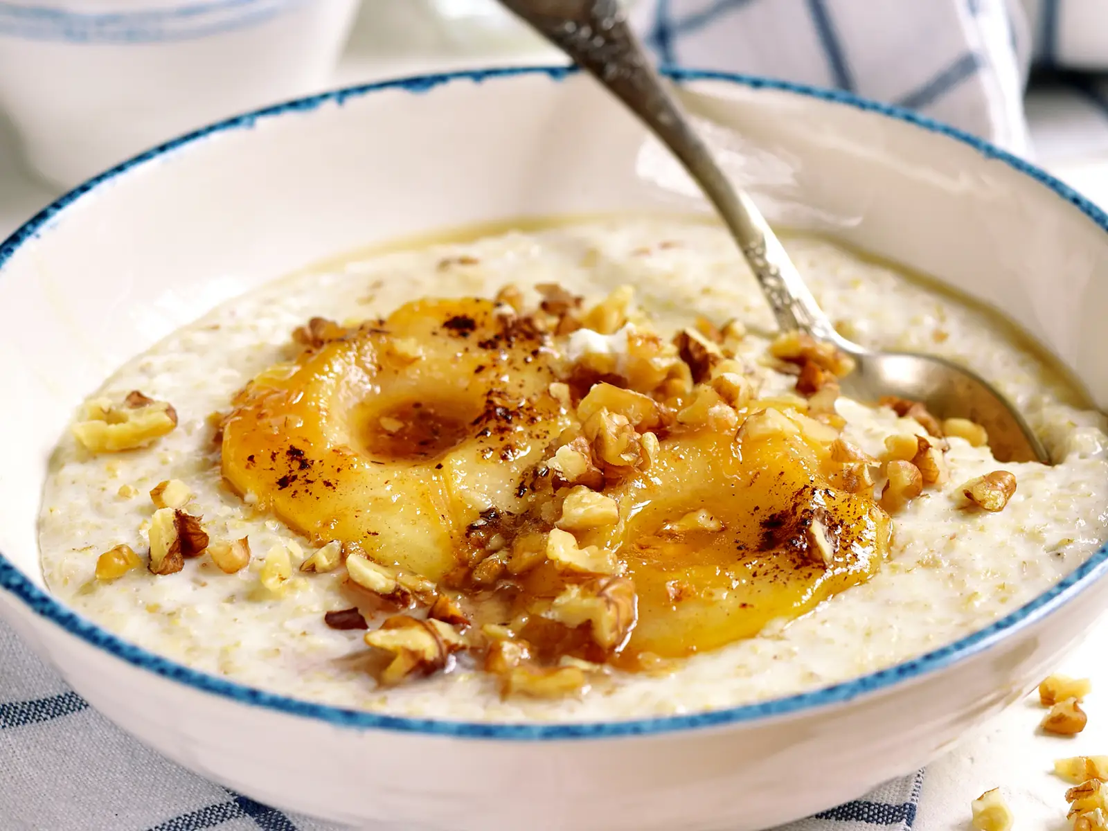 Apfel-Birnen-Porridge mit Zimt und einer Nussgarnitur in einer Schale. | VIACTIV Krankenkasse