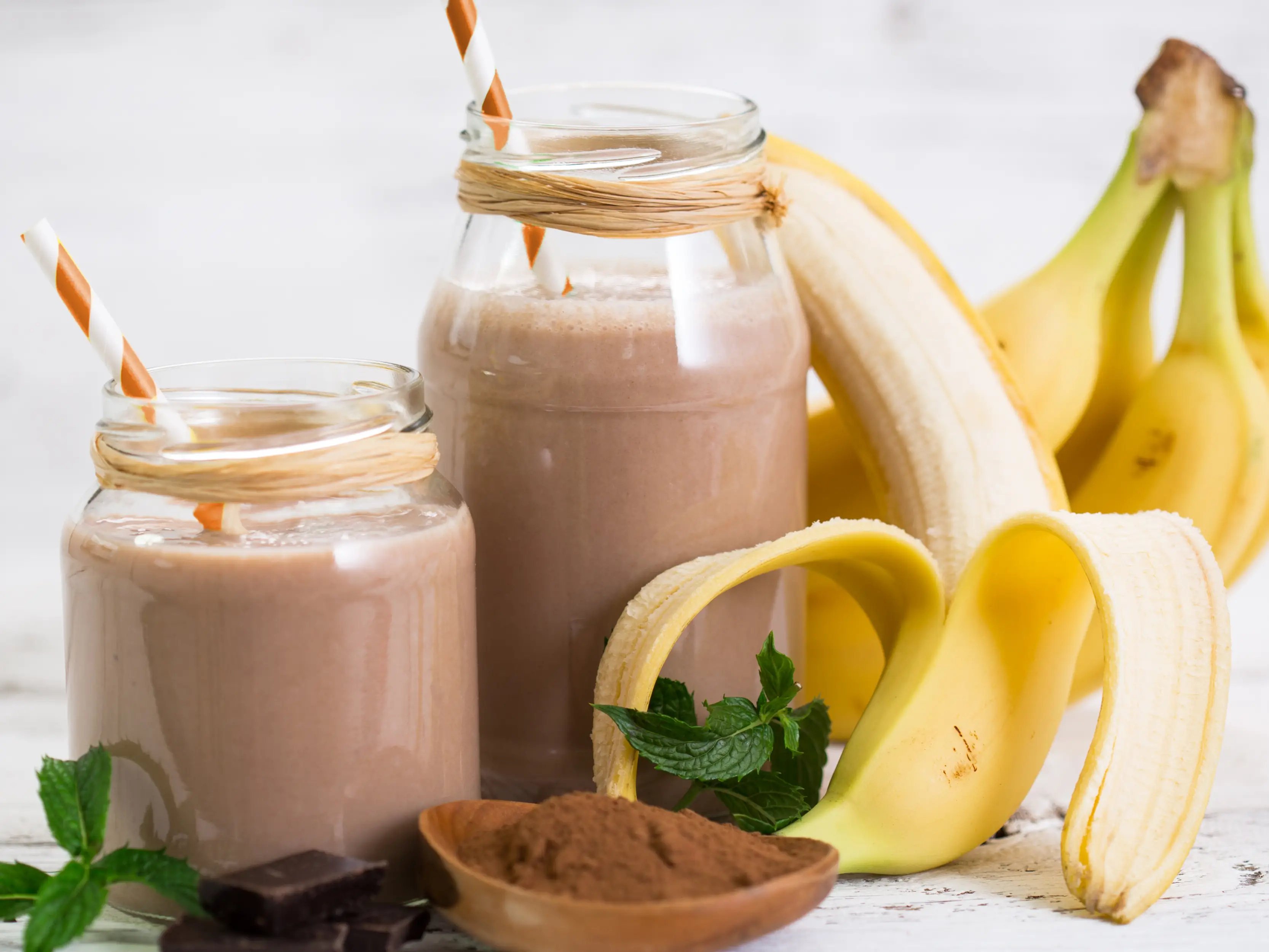 Ein Soja-Bananendrink mit Kakao in einem Glas mit Strohhalm. | VIACTIV Krankenkasse