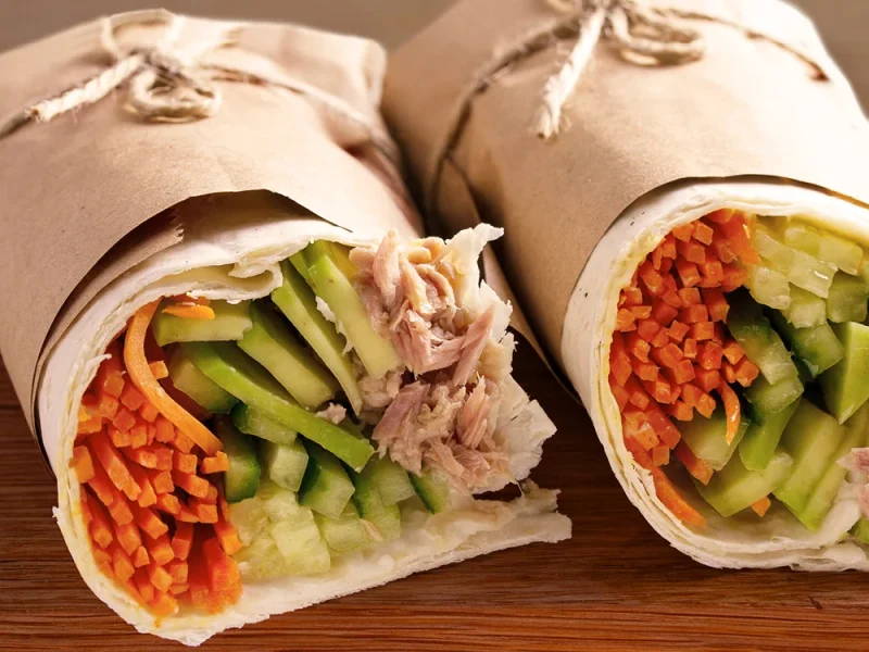 Zwei Wraps mit Möhre, Gurke und Thunfisch in braunem Papier. | VIACTIV Krankenkasse