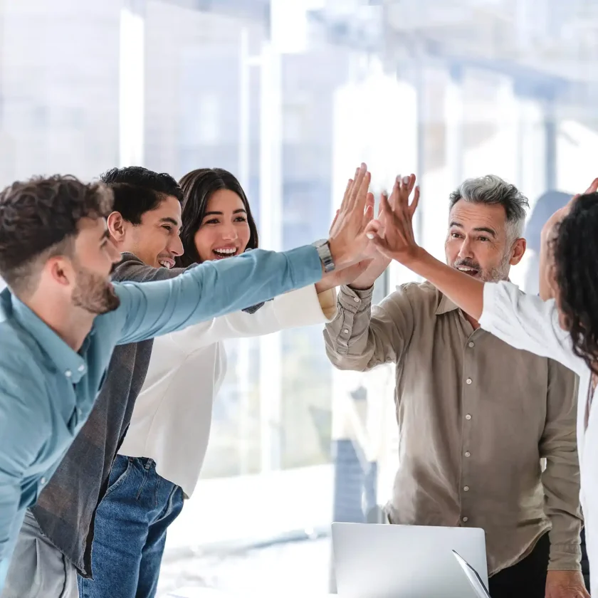 Fünf Personen im Business-Look geben sich ein High Five als Zeichen von Teamwork. | VIACTIV Krankenkasse