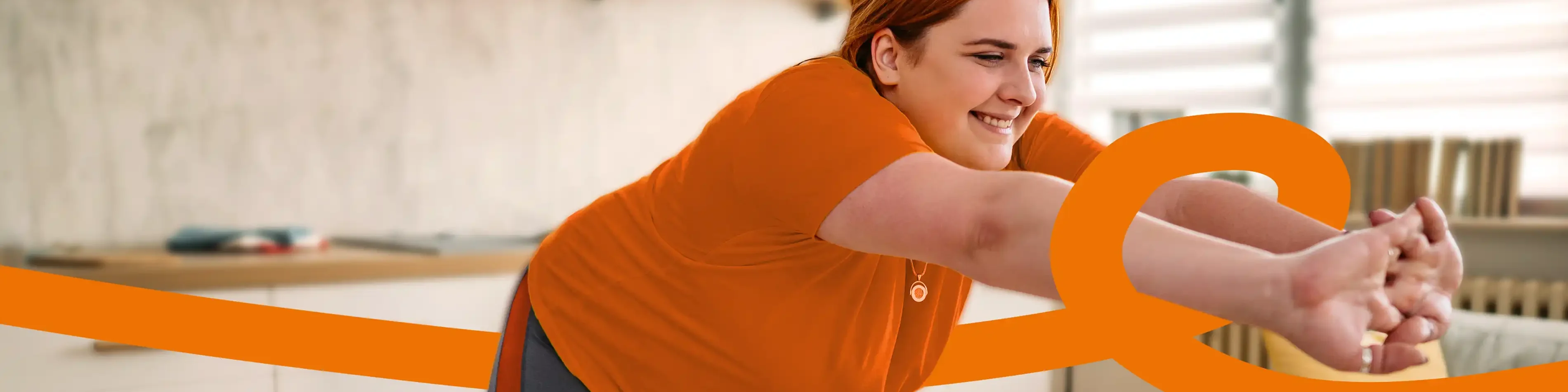 Eine Frau steht in der Küche und macht Dehnübungen. | VIACTIV Krankenkasse