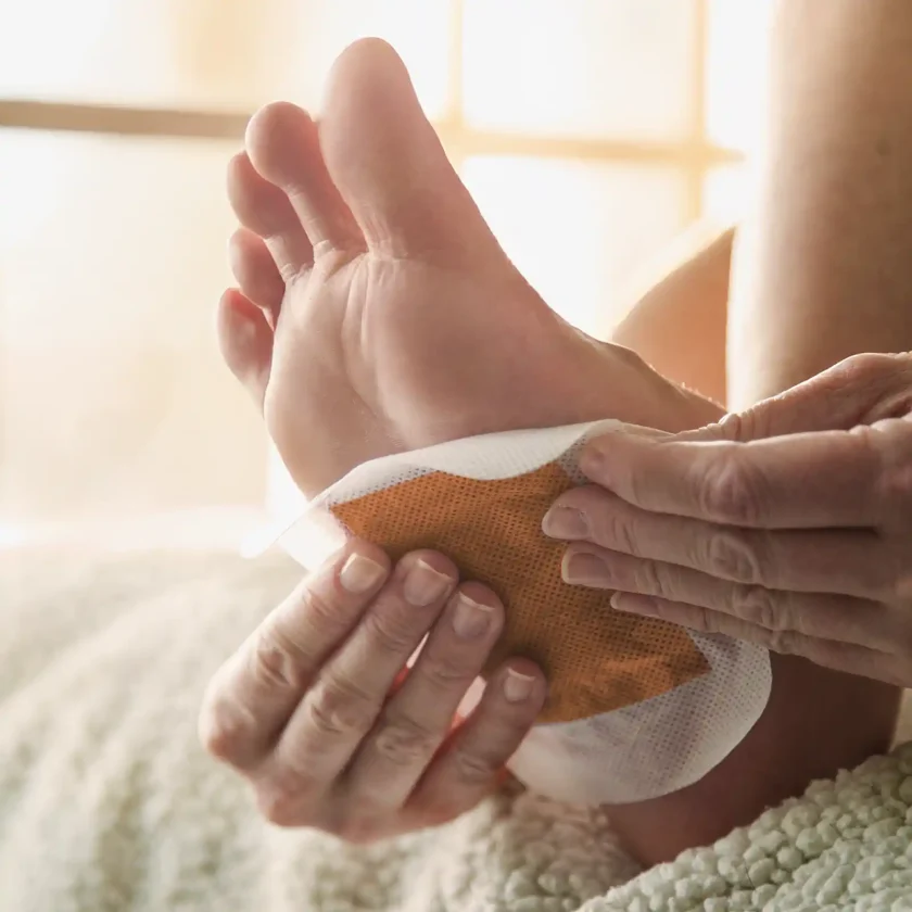 Eine Person klebt sich ein Entgiftungspflaster unter den Fuß. | VIACTIV Krankenkasse