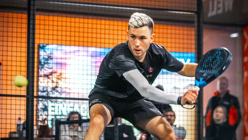 Ein Mann in einer Indoor-Padel-Anlage, der gerade den Ball schlägt. | VIACTIV Krankenkasse
