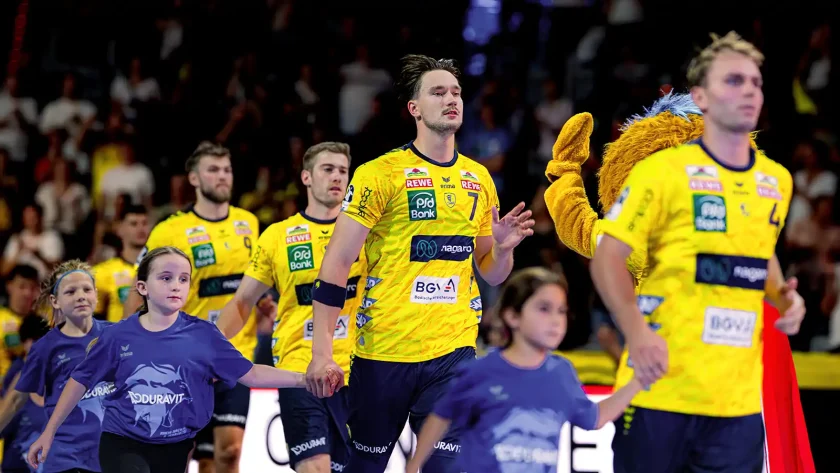 Eine Gruppe von Handballspielern der Rhein-Neckar Löwen läuft mit Kindern in die Turnhalle ein. | VIACTIV Krankenkasse