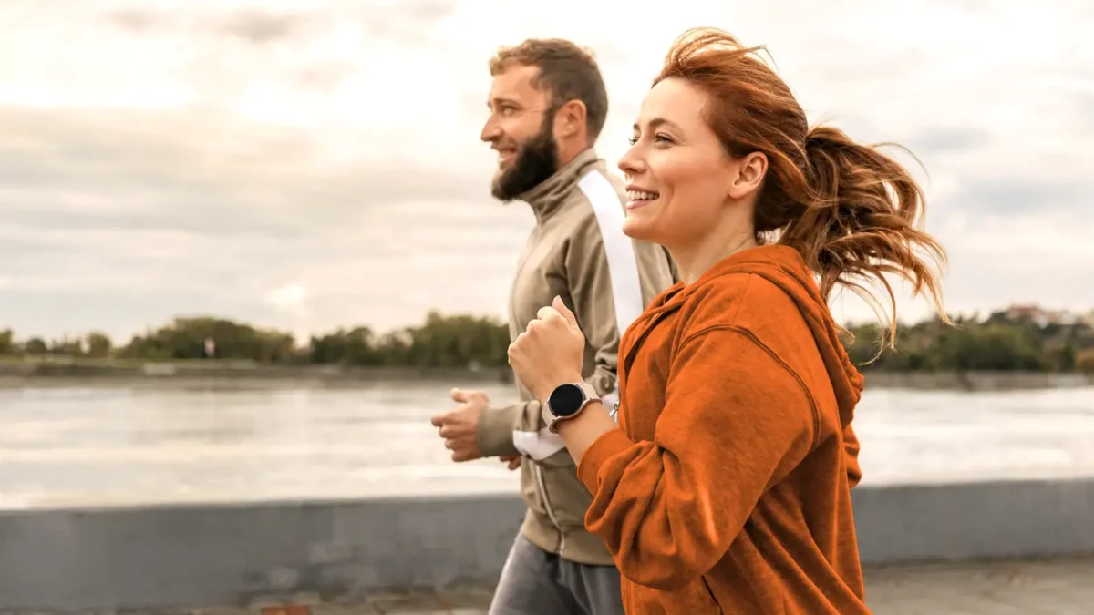 Zwei junge Menschen joggen draußen nebeneinander. | VIACTIV Krankenkasse