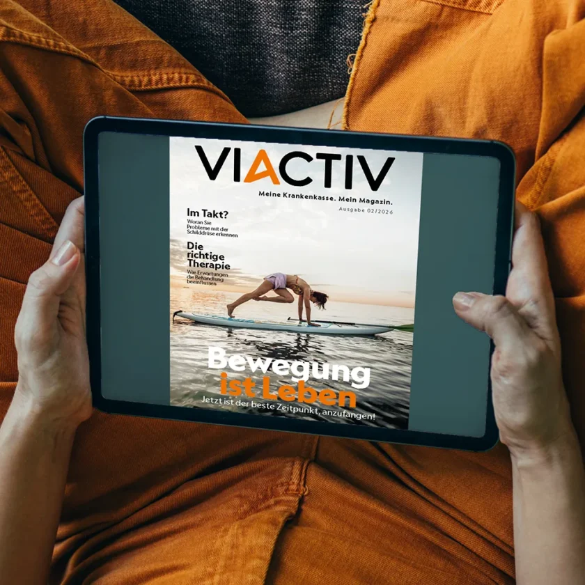 Jemand hält ein Tablet in der Hand. Auf dem Display ist die Sommerausgabe des VIACTIV Magazins 2026 abgebildet. | VIACTIV Krankenkasse