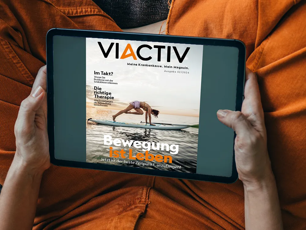 Jemand hält ein Tablet in der Hand. Auf dem Display ist die Sommerausgabe des VIACTIV Magazins 2026 abgebildet. | VIACTIV Krankenkasse