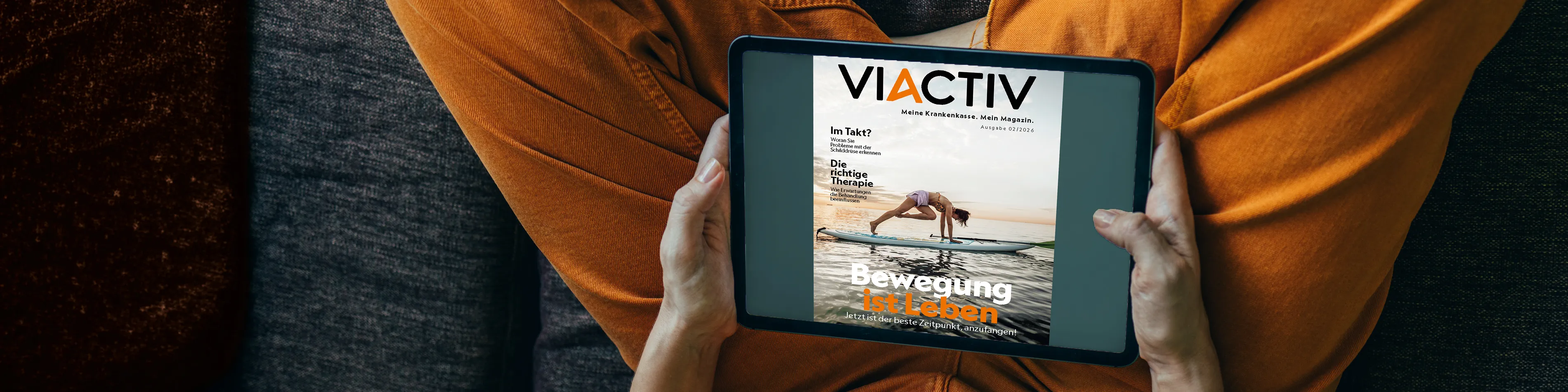 Jemand hält ein Tablet in der Hand. Auf dem Display ist die Sommerausgabe des VIACTIV Magazins 2026 abgebildet. | VIACTIV Krankenkasse