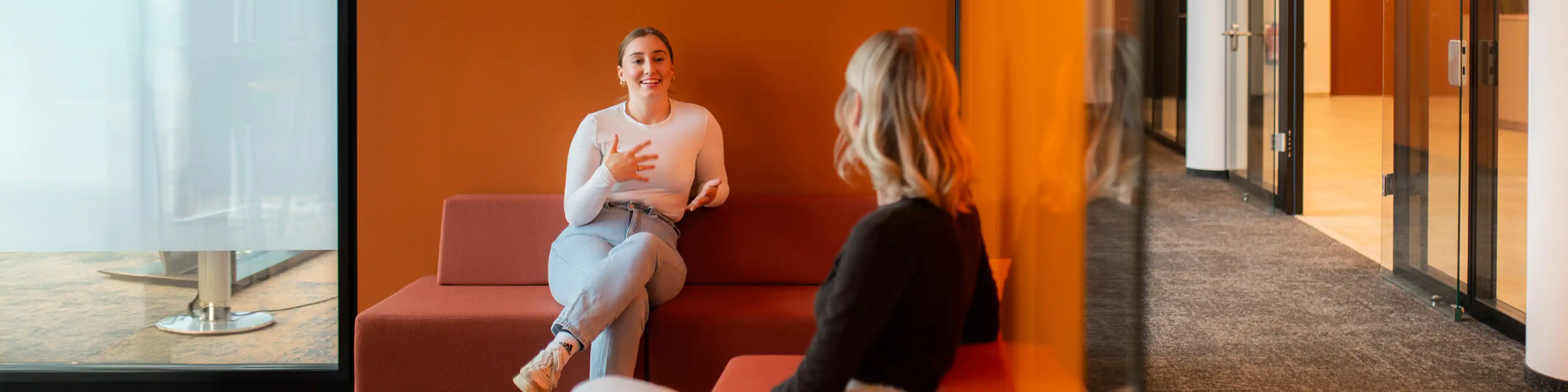 Zwei Mitarbeiterinnen der VIACTIV unterhalten sich. Sie sitzen sich schräg gegenüber. | VIACTIV Krankenkasse