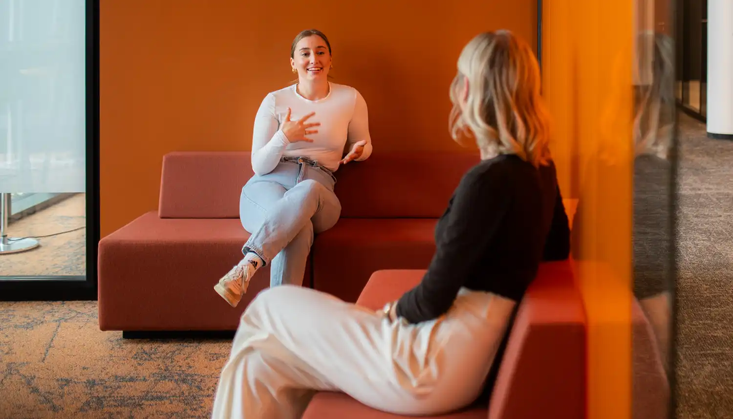 Zwei Mitarbeiterinnen der VIACTIV unterhalten sich. Sie sitzen sich schräg gegenüber. | VIACTIV Krankenkasse