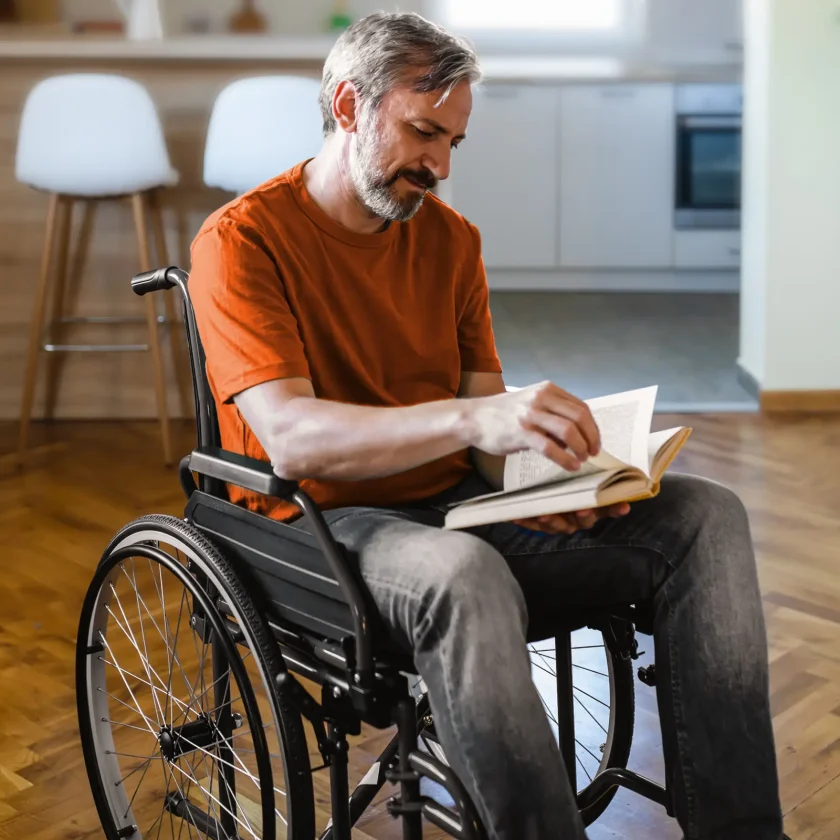 Ein Mann im Rollstuhl liest ein Buch. | VIACTIV Krankenkasse