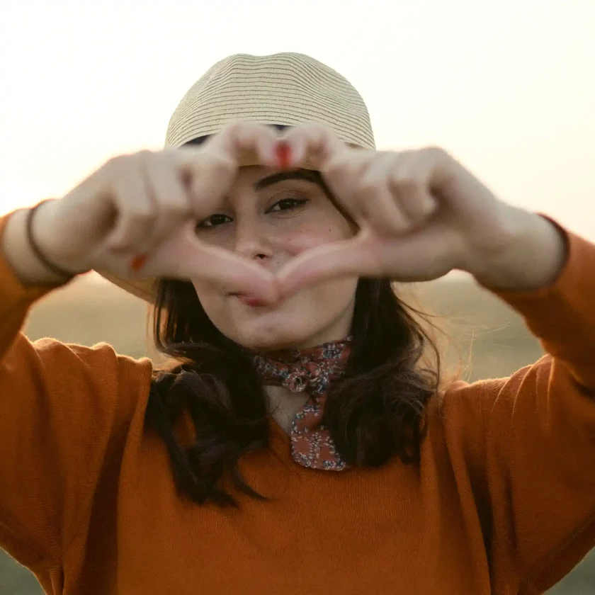 Eine junge Frau formt mit ihren Fingern ein Herz in die Kamera. | VIACTIV Krankenkasse