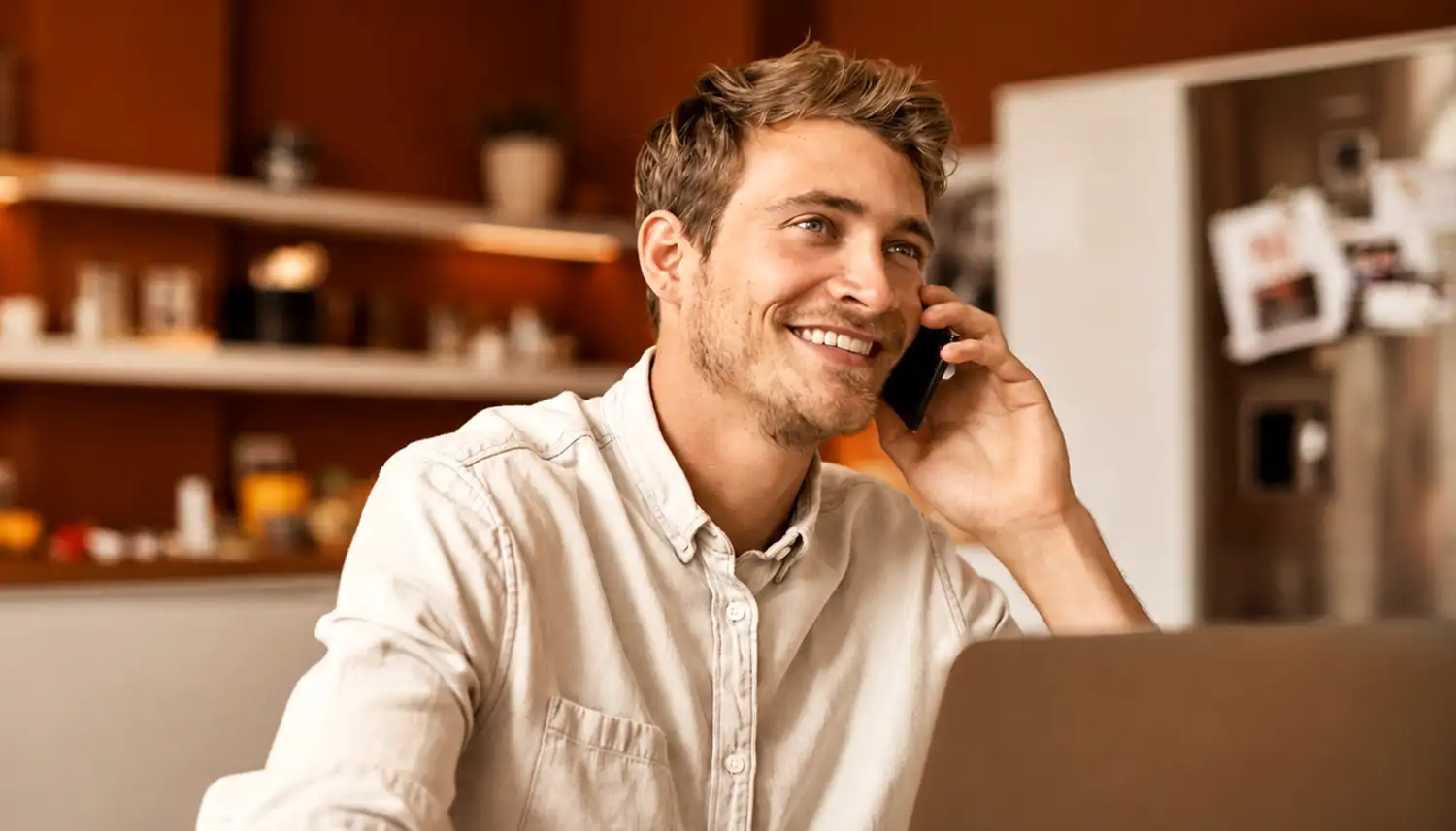 Ein Mann telefoniert mit seinem Mobiltelefon und lächelt dabei. | VIACTIV Krankenkasse