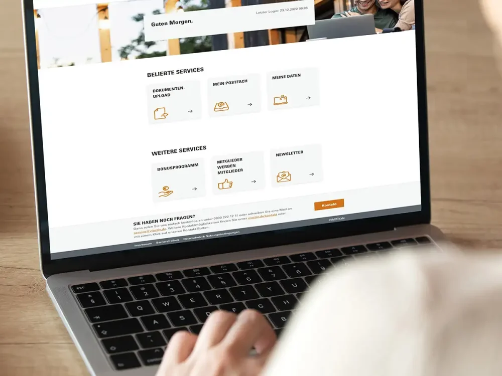 Eine Person sitzt vor einem aufgeklappten Laptop. Auf dem Bildschirm ist die 'Startseite des digitalen Kundenservice „VIACTIV Service-Online“ zu sehen. | VIACTIV Krankenkasse