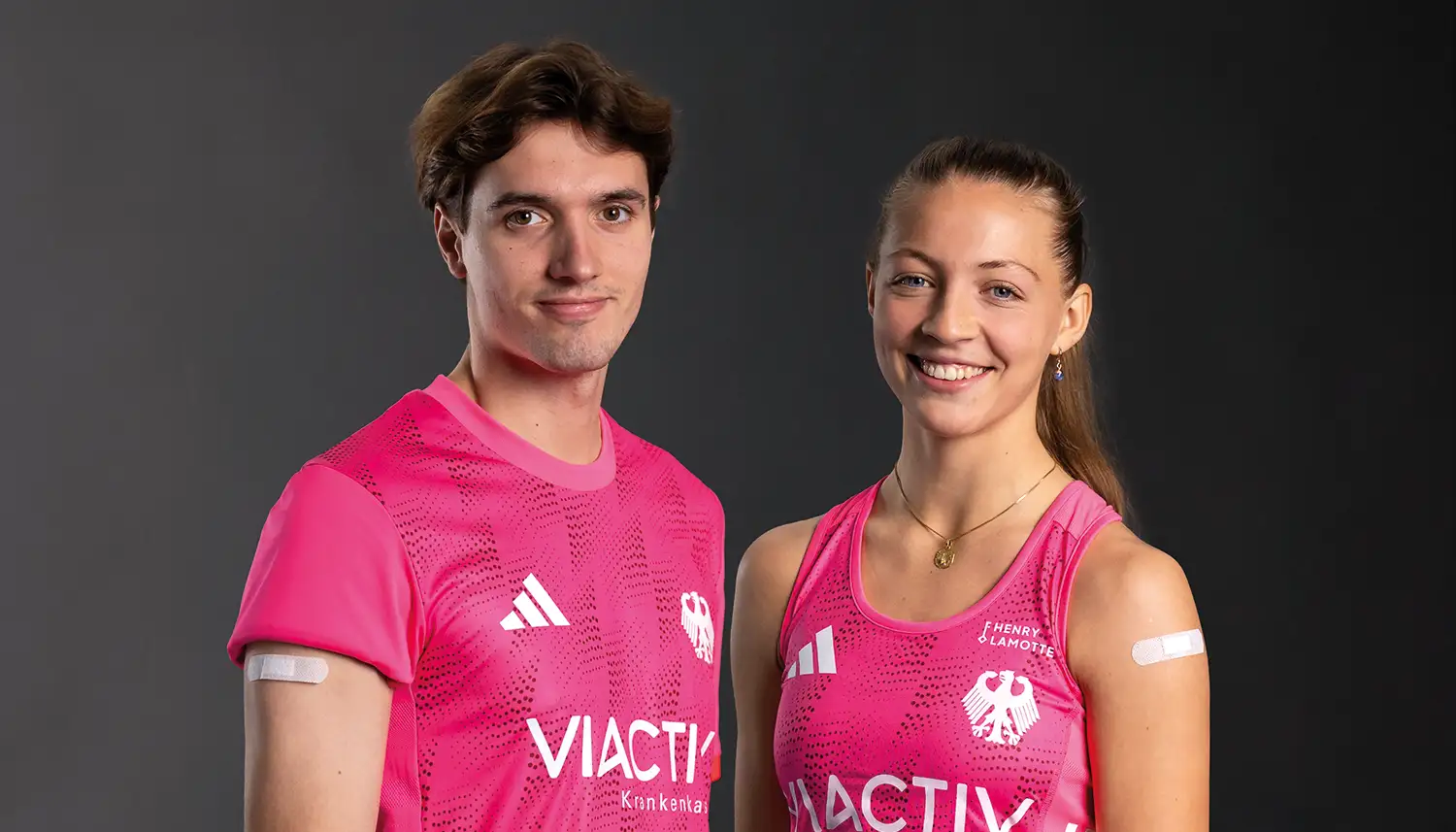 Ein Spieler und eine Spielerin vom Deutschen Hockey Bund stehen nebeneinander. Beide haben ein Pflaster auf dem Arm. | VIACTIV Krankenkasse