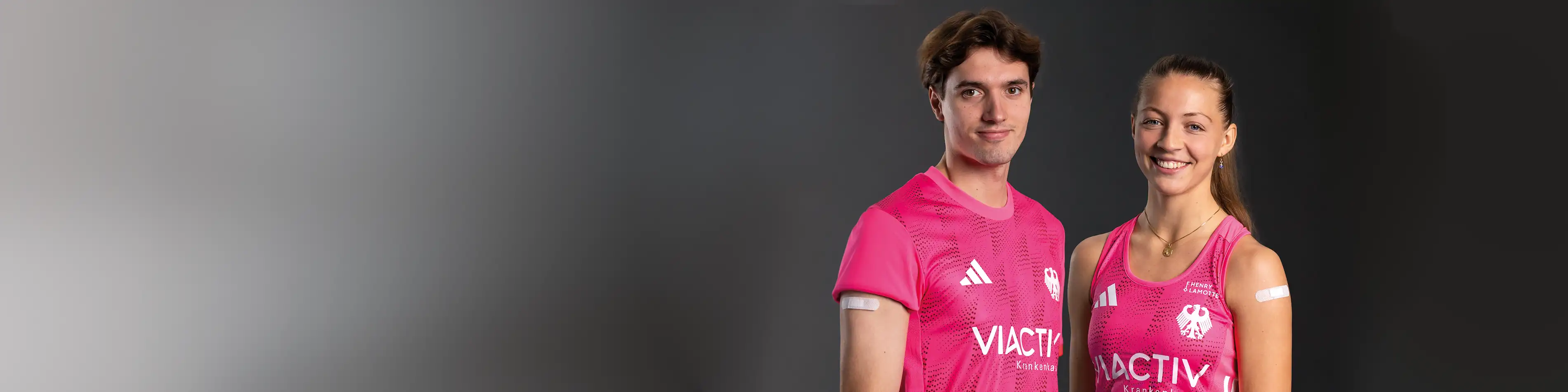 Ein Spieler und eine Spielerin vom Deutschen Hockey Bund stehen nebeneinander. Beide haben ein Pflaster auf dem Arm. | VIACTIV Krankenkasse