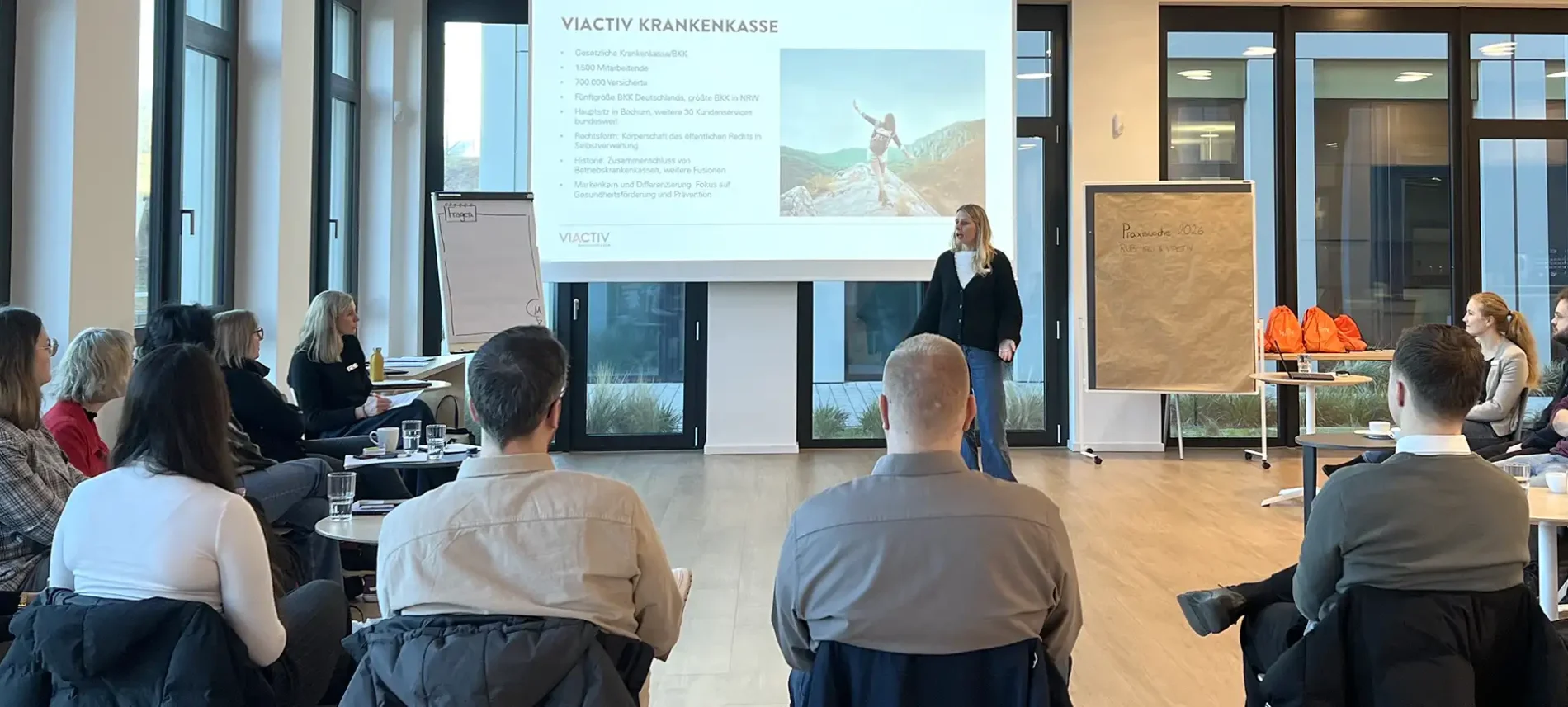 Eine Gruppe von Studenten sitzt im Stuhlkreis. Sie hören sich eine Präsentation der VIACTIV Krankenkasse an. | VIACTIV Krankenkasse