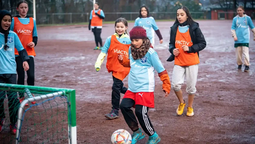 Ein kleines Mädchen stürmt mit dem Ball auf ein Tor zu. Sie nimmt teil an der Aktion 