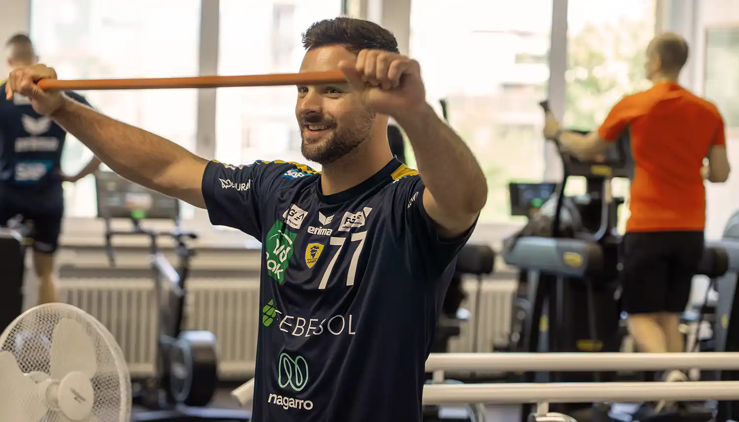 Ein Sportler der Rhein-Neckar Löwen trainiert mit einem Theraband. | VIACTIV Krankenkasse