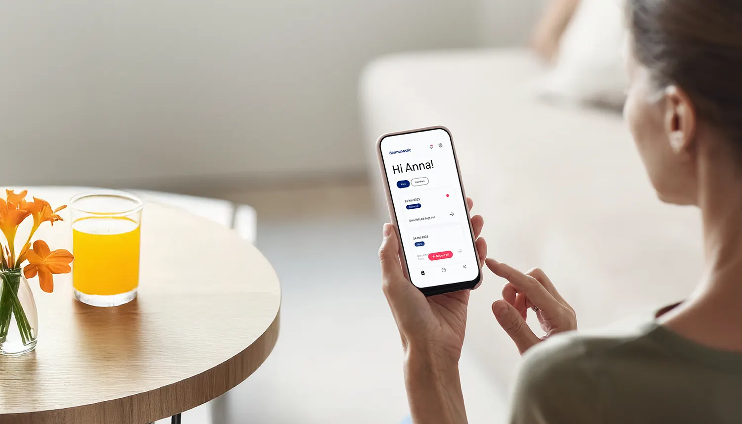 Eine Frau hat die Hautarzt-App von Dermanostic auf ihrem Smartphone geöffnet. Sie schaut auf ihr Handy. | VIACTIV Krankenkasse